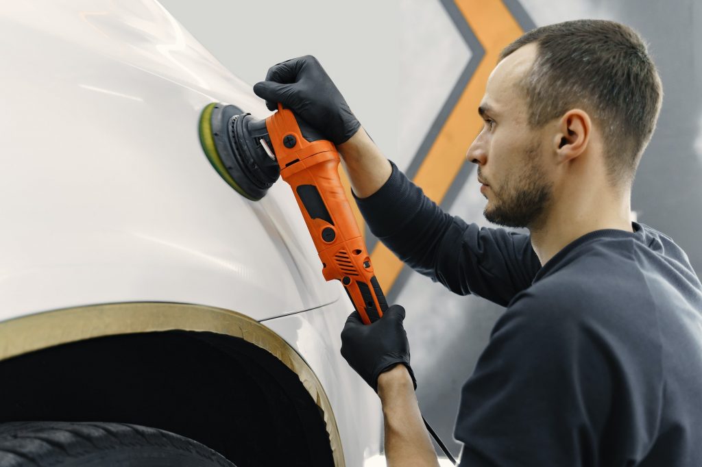 Man polish a car in a garage