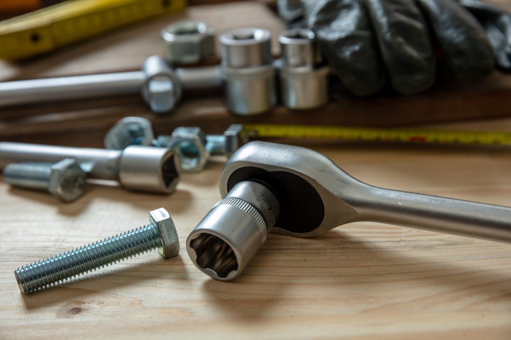 Torque wrench, work tool on wooden background. Hand tool for screw and nut tighten.